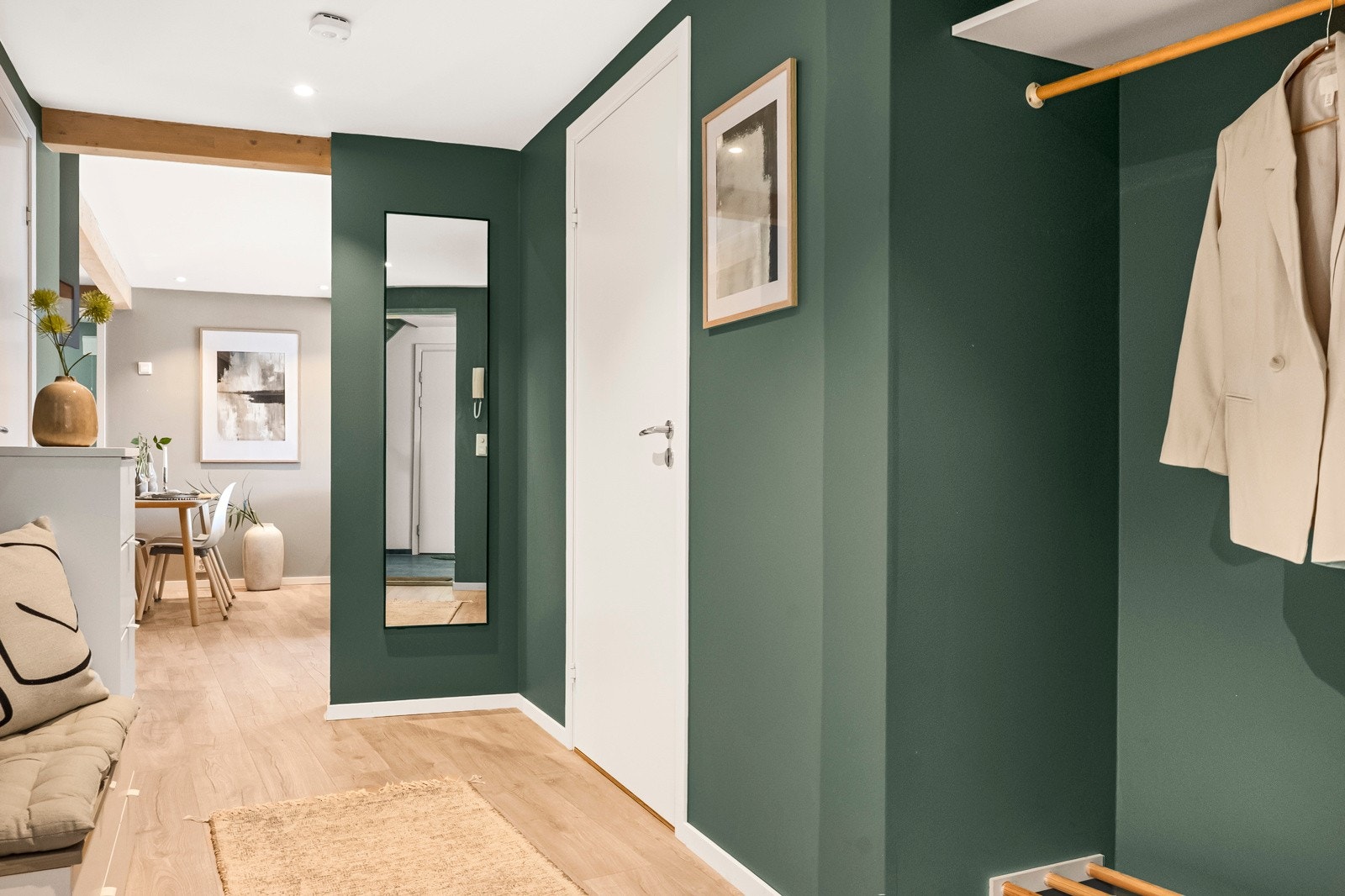 Romslig gang med stilrene detaljer og gjennomgående moderne uttrykk. De mørke veggtonene skaper en lun kontrast til de lyse overflatene og gulvet. Galleribilde