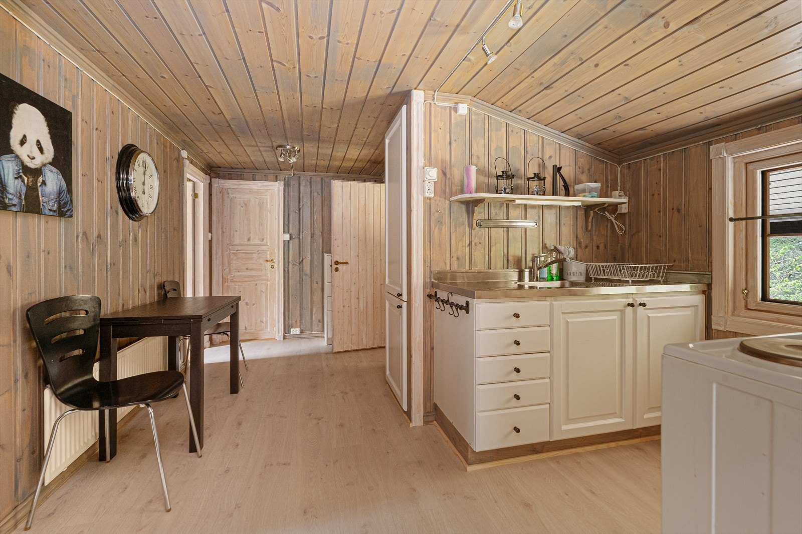 Kjøkkeninnredning med glatte fronter, laminatbenkeplate og kjøkkenventilator med avtrekk ut. Galleribilde