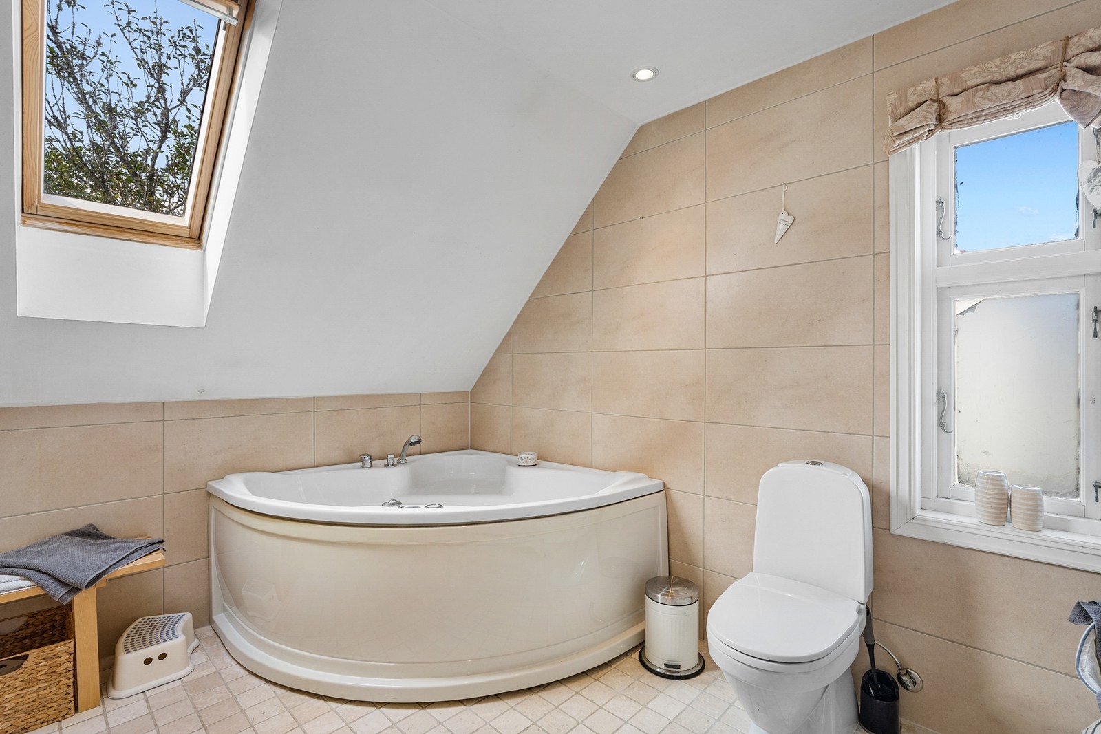 Badet er innredet med toalett, dobbel servant i baderomsmøbel, badekar og dusjsone. Galleribilde