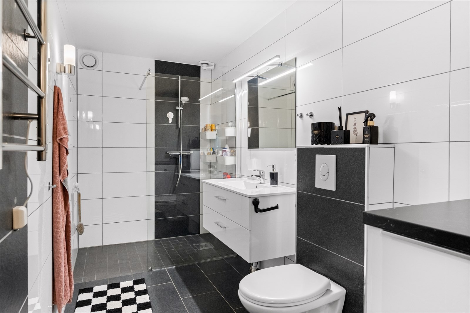 Badet er moderne og pent, med hvite fliser på veggene og grå fliser på gulv med gulvvarme. Galleribilde