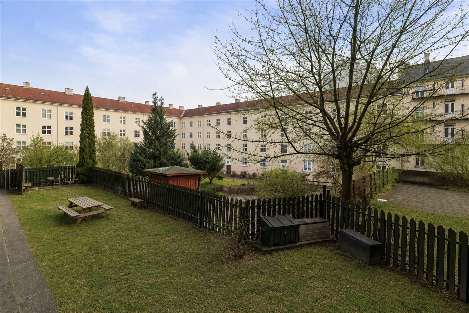 Her bor du i et hyggelig sameie med en usjenert felles bakgård til flittig bruk av beboerne (Redigert med AI) Galleribilde