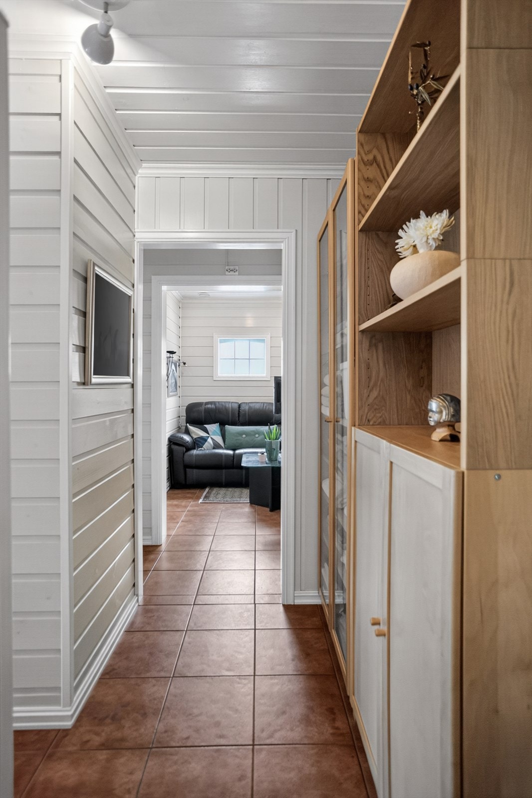 Gjennomgående materialvalg som fliser og panel skaper en helhetlig stil i boligen. Galleribilde
