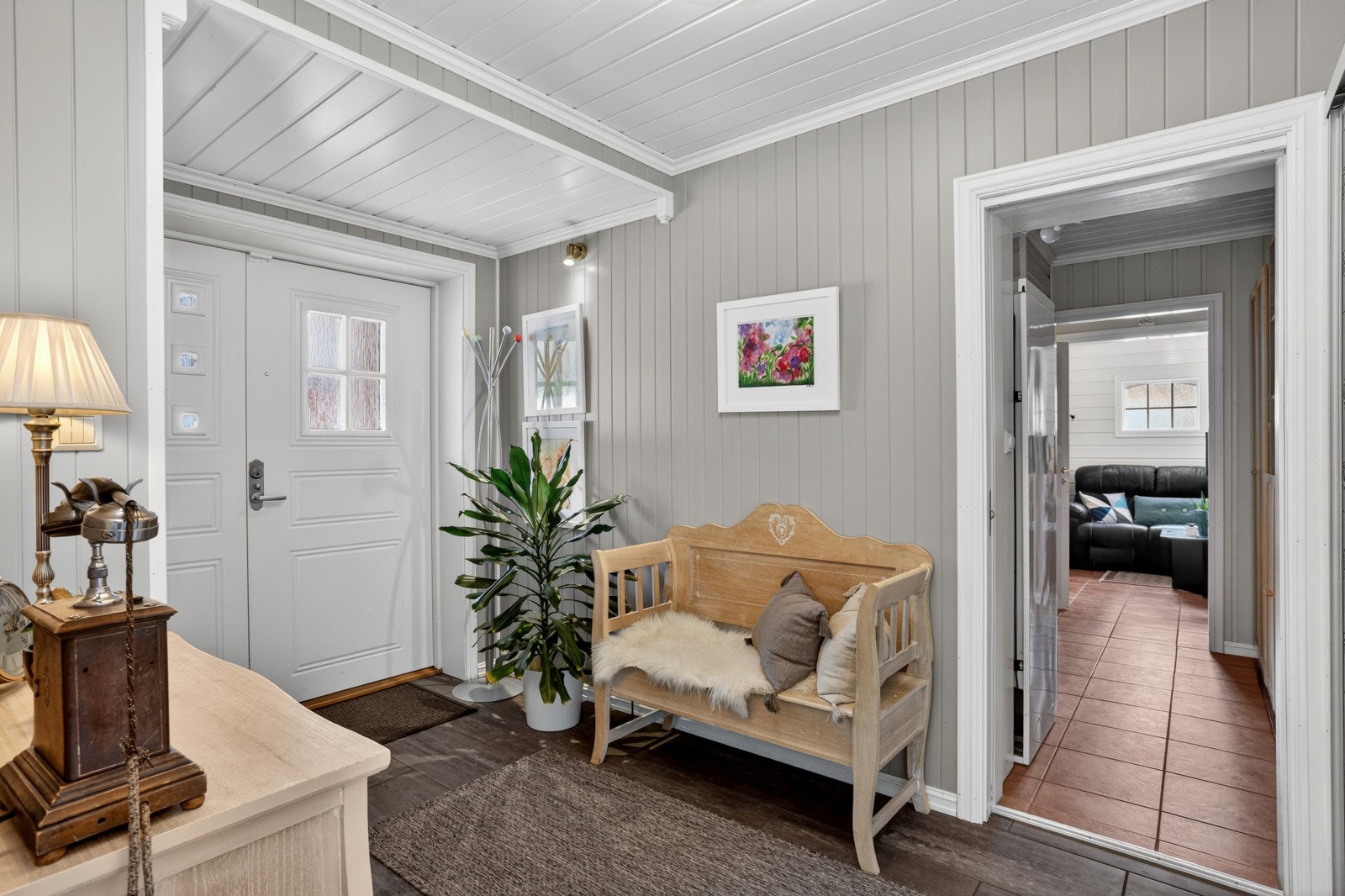 Inngangspartiet ønsker velkommen med malt panel på vegger og tak, og gir et godt førsteinntrykk av boligens karakter. Galleribilde