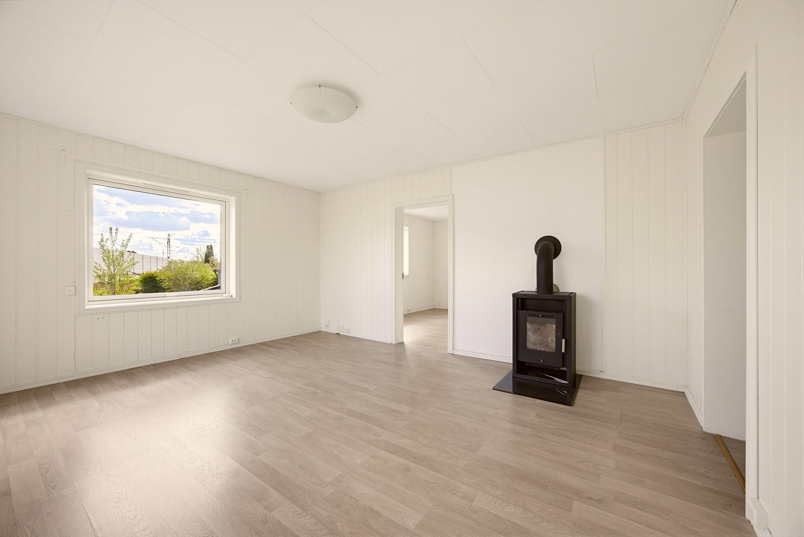 Stuen har en praktisk og enkel planløsning som er lett å innrede, samt peis, laminatgulv og panel på veggene som gir et lunt og hyggelig preg. Galleribilde