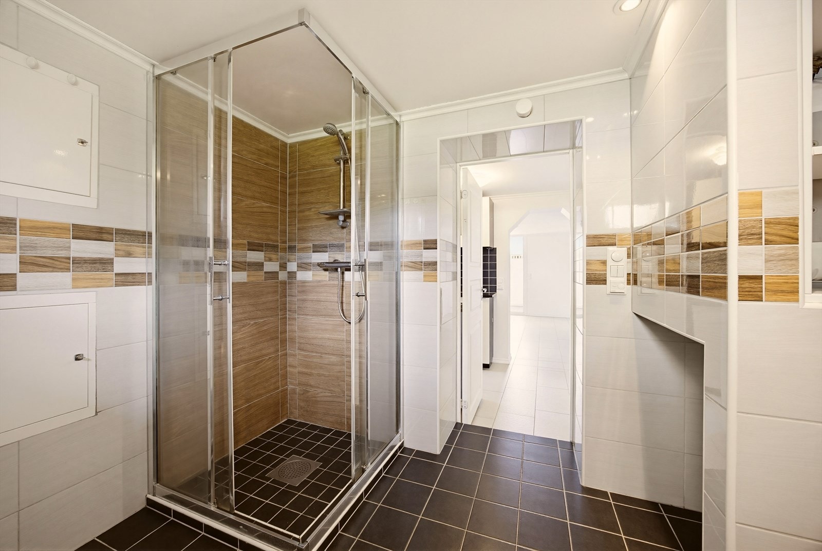 Badet er utstyrt med vegghengt toalett, bidet, dusj med skyvbare glassdører og har opplegg for vaskemaskin. Galleribilde
