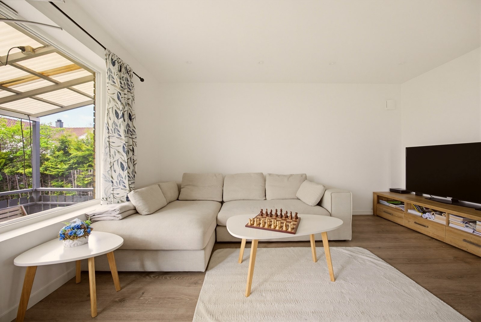 Rommet har peis, laminatgulv og store vinduer som slipper inn rikelig med naturlig lys, samt lyse vegger som forsterker den luftige følelsen. Galleribilde