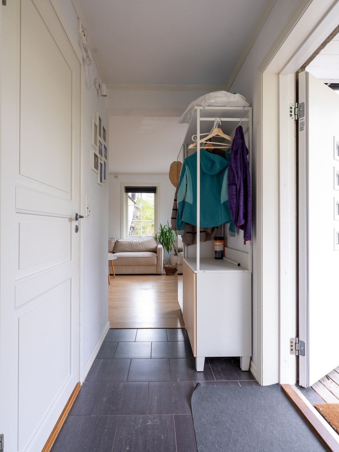 Inngang til boligen via nedsiden av huset. Entréen har fin plass til oppbevaringsmøblement. Galleribilde