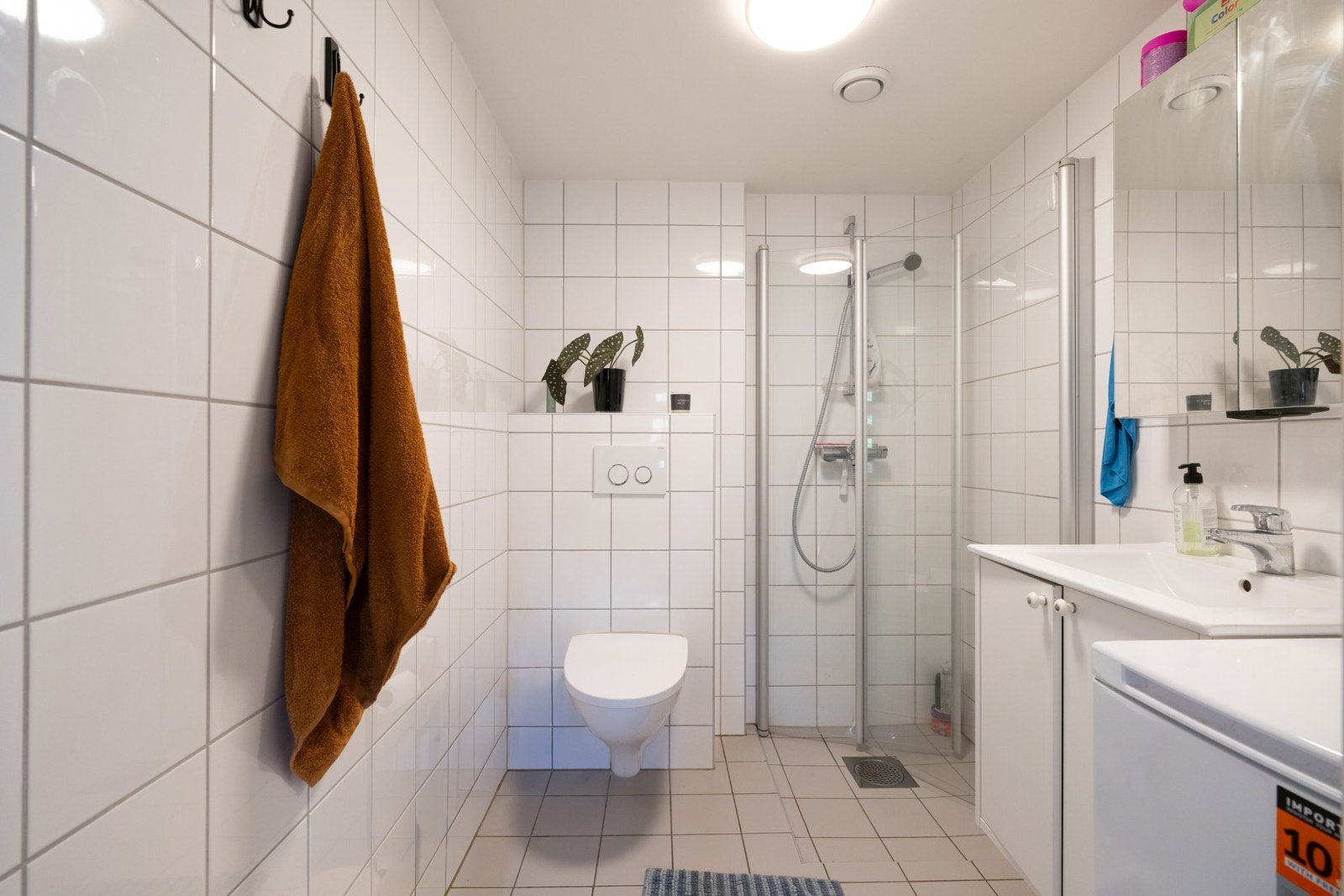 Lyst, flislagt bad med opplegg for vaskemaskin. Vaskemaskin blir stående. Galleribilde