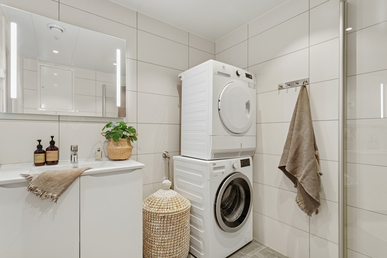 Badet er utstyrt med dusjhjørne med glassdører og servantinnredning. Rørfordelerskap er plassert her. Galleribilde