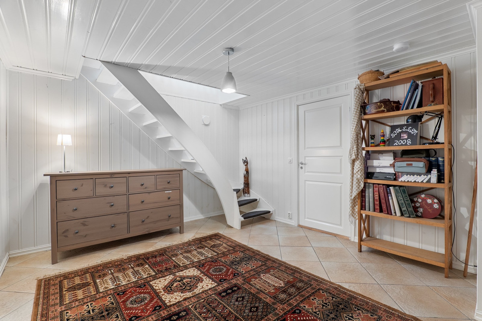 Innvendig trapp leder direkte mellom entreen og underetasjens romslige gang. Ved gangen finnes et soverom som er naturlig tilknyttet boligens hoveddel. Galleribilde