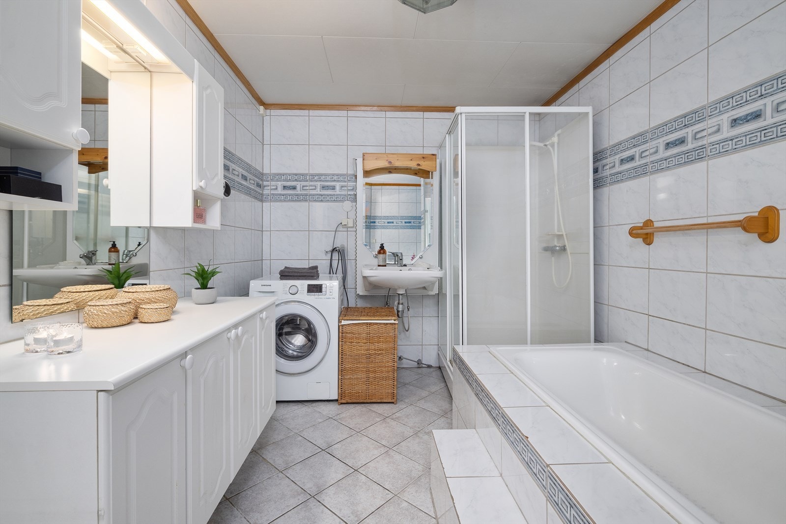 Badet er utstyrt med både dusjkabinett og innebygget badekar, samt opplegg for vaskemaskin. Galleribilde