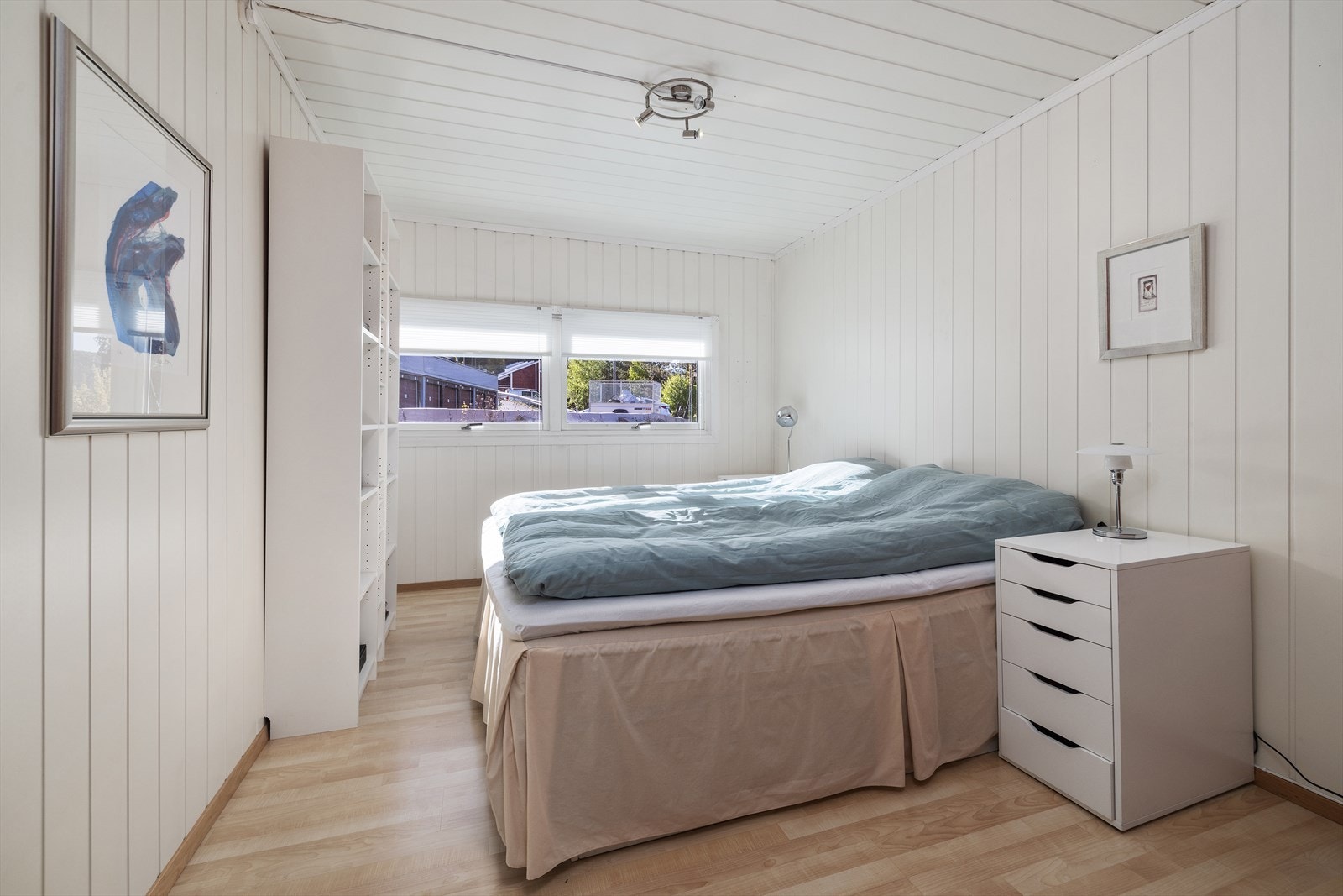 Et av etasjens tre soverom, med laminat på gulv og malte panelplater på veggene. Galleribilde