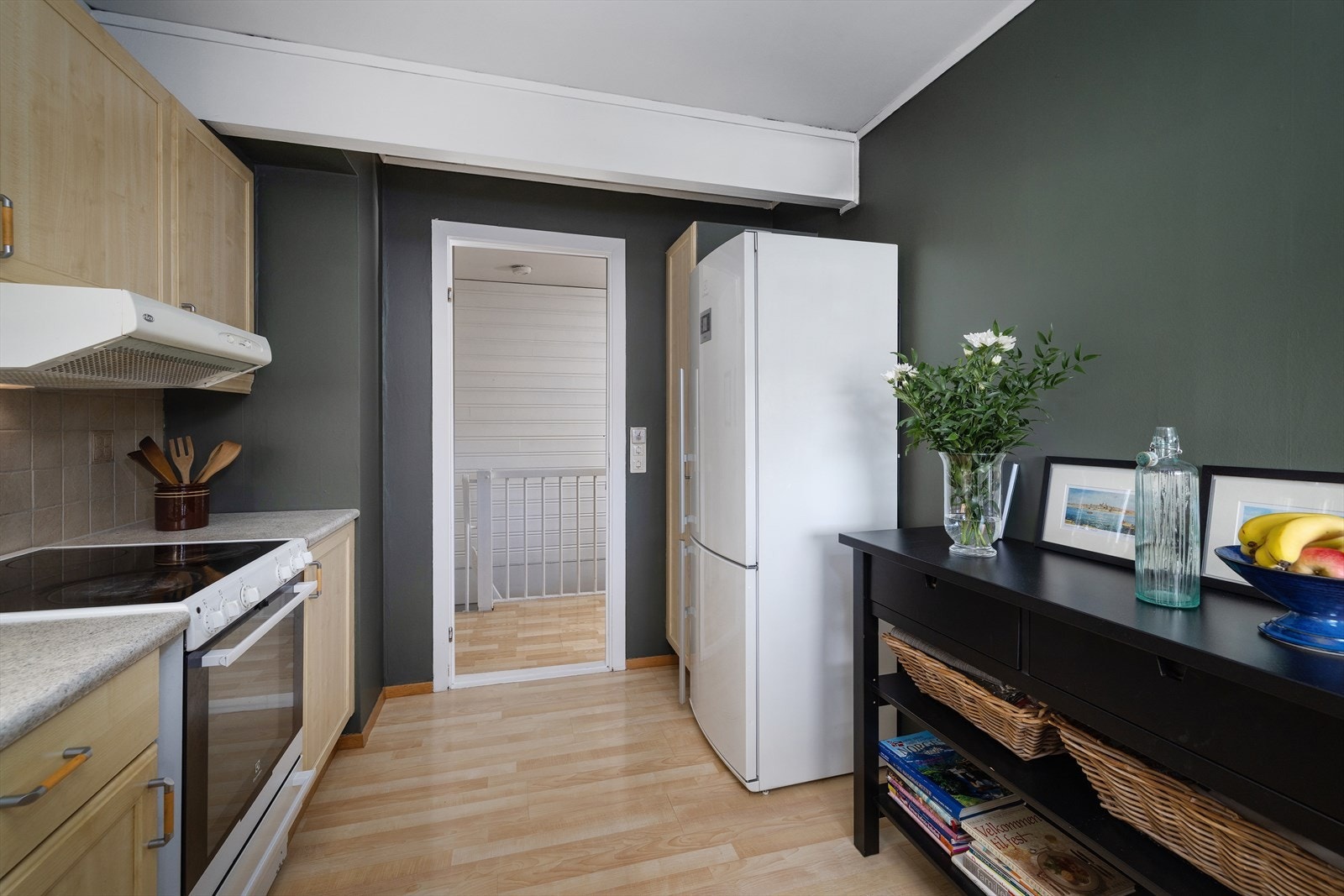 Kjøkkenet har ventilator med avtrekk ut og fliser mellom overskap og benk. Galleribilde