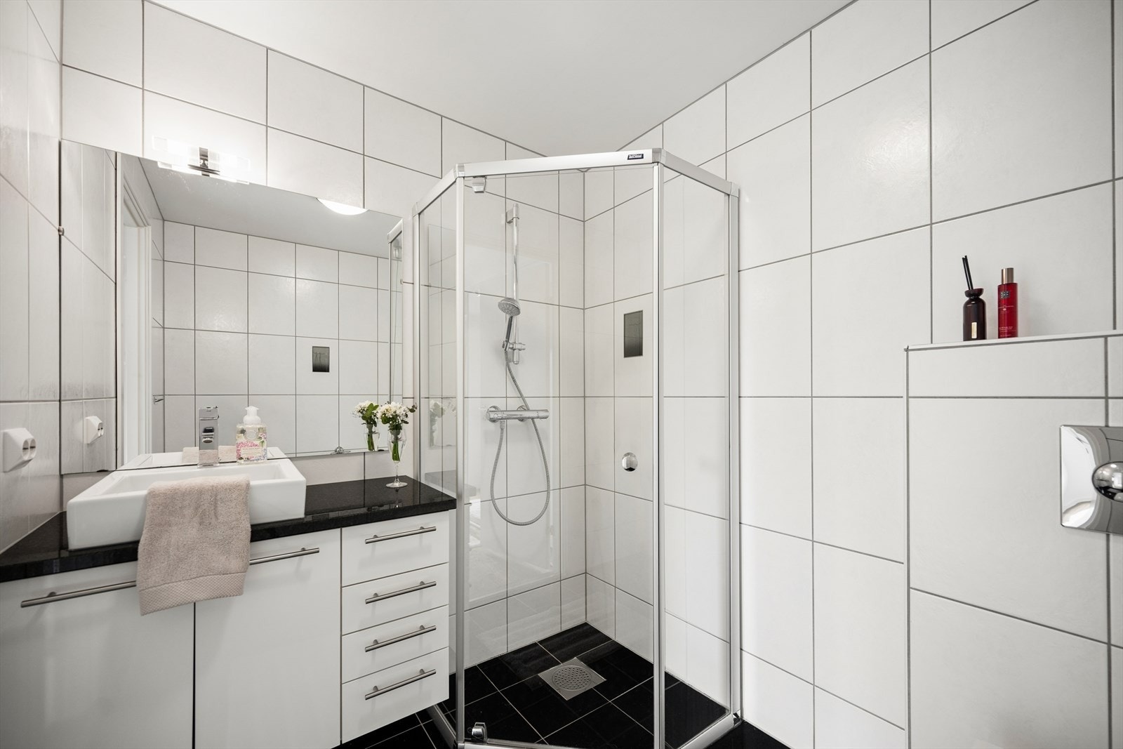 Bad tilknyttet hovedsoverom - Det private badet er fra byggeåret, fliser på vegg og gulv med varmekabler. Innredning på bad med speil, benkeskap, servant og blandebatteri. Toalett montert på vegg. Dusj med glassdør. Balansert ventilasjon. Galleribilde