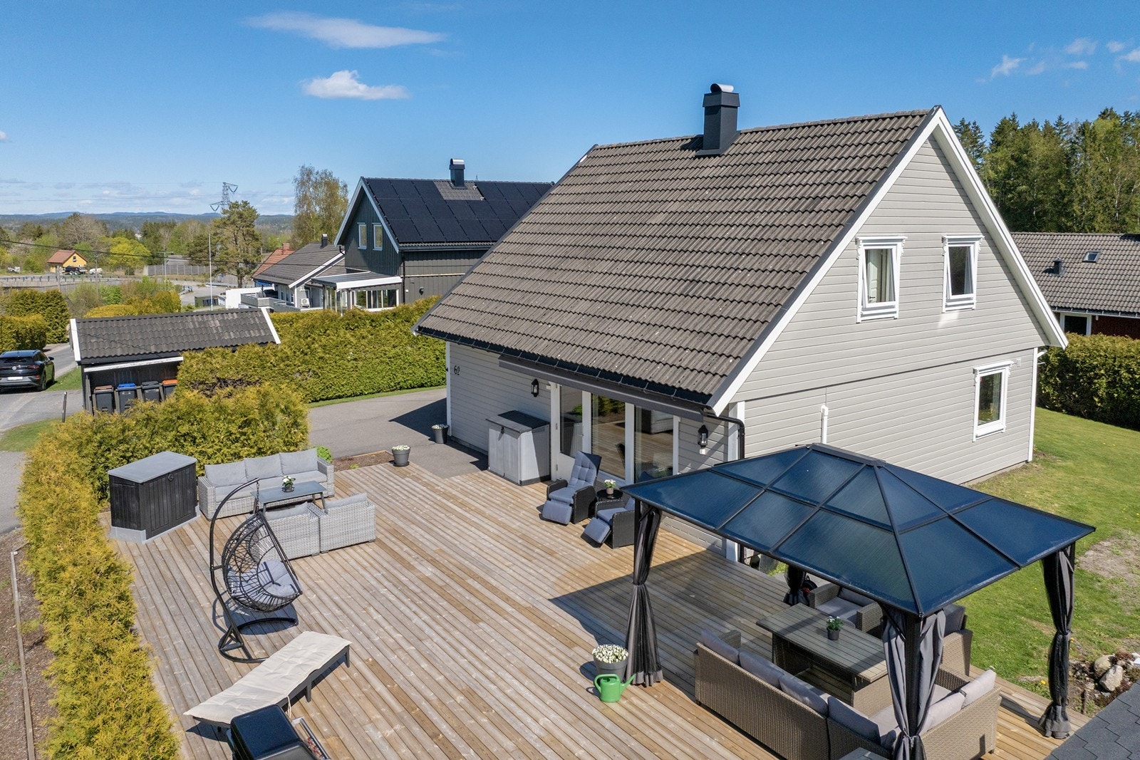 Tomten er opparbeidet med asfaltert gårdsplass, plen og hekk. Galleribilde