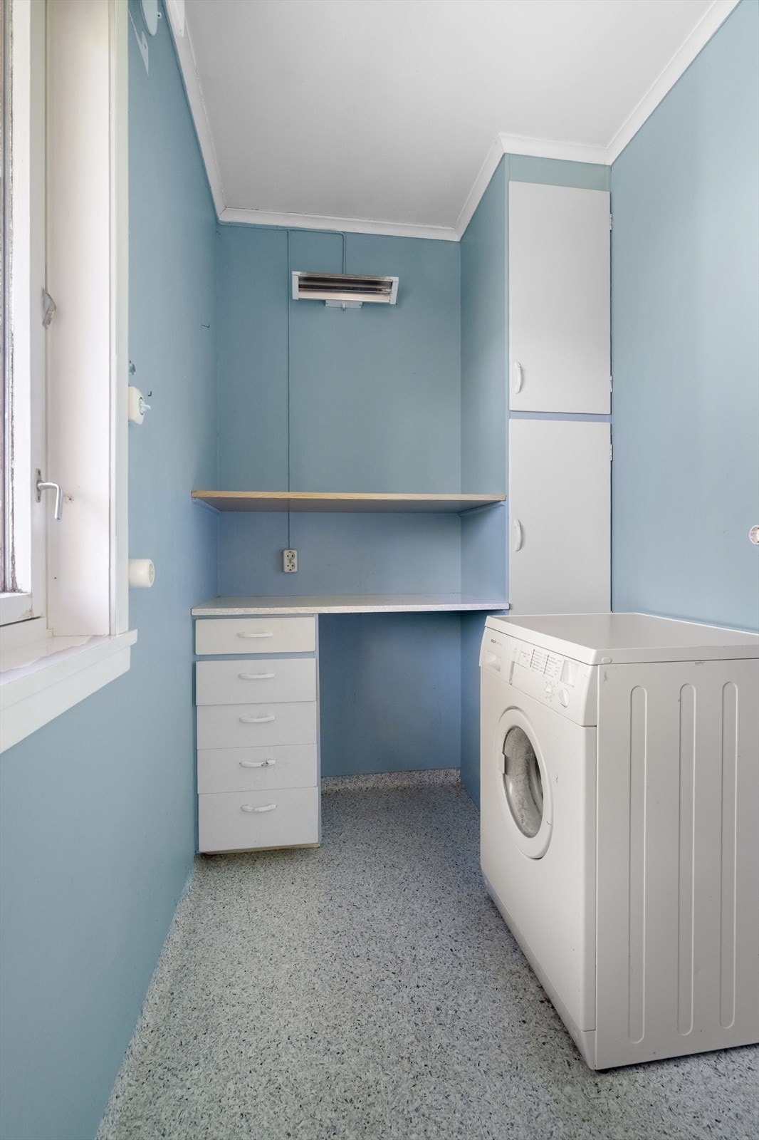 Praktisk vaskerom med vinylbelegg på gulv, sluk og opplegg for vaskemaskin. Galleribilde