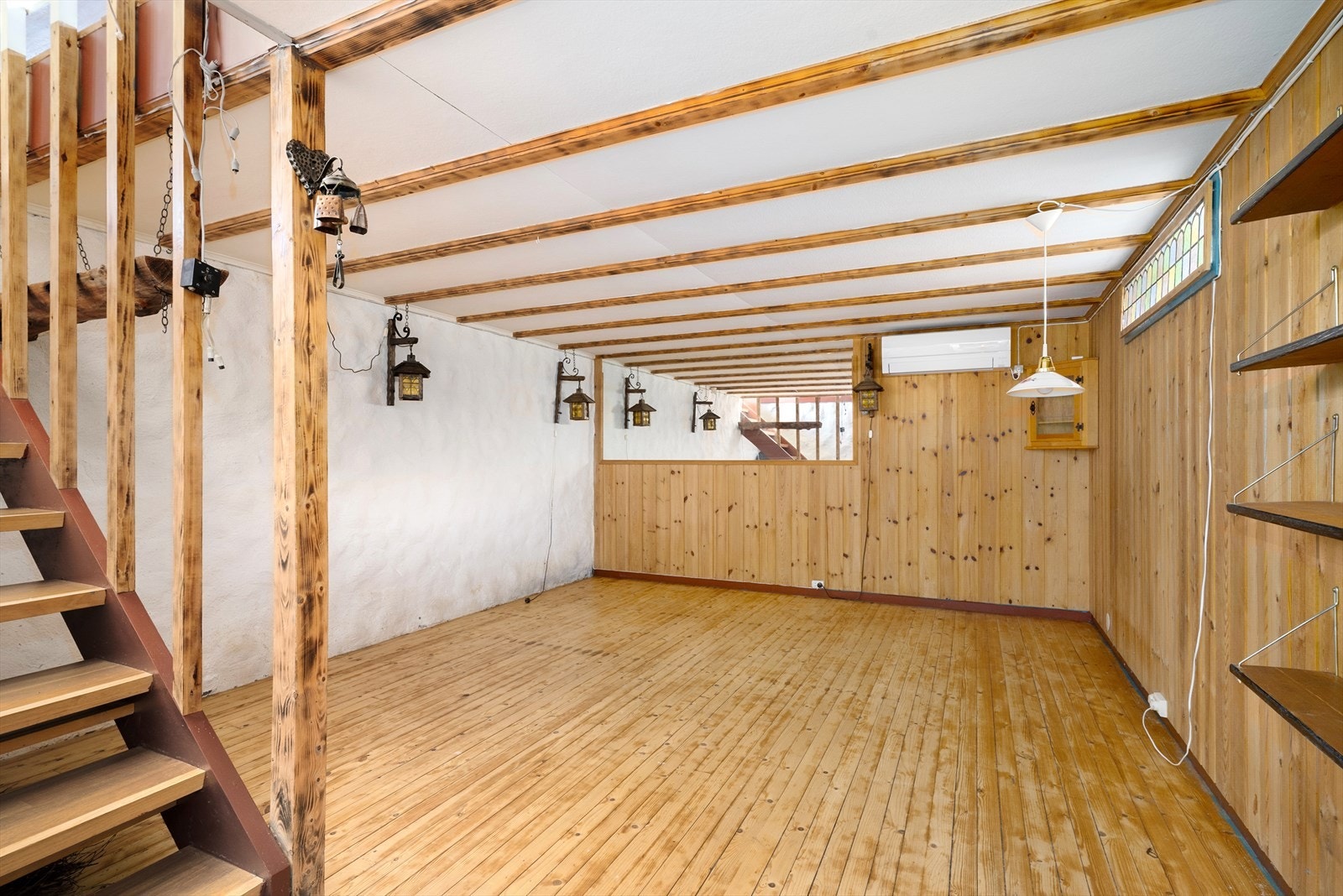 Innredet rom i kjelleren med furugulv og panel på deler av veggene. Galleribilde