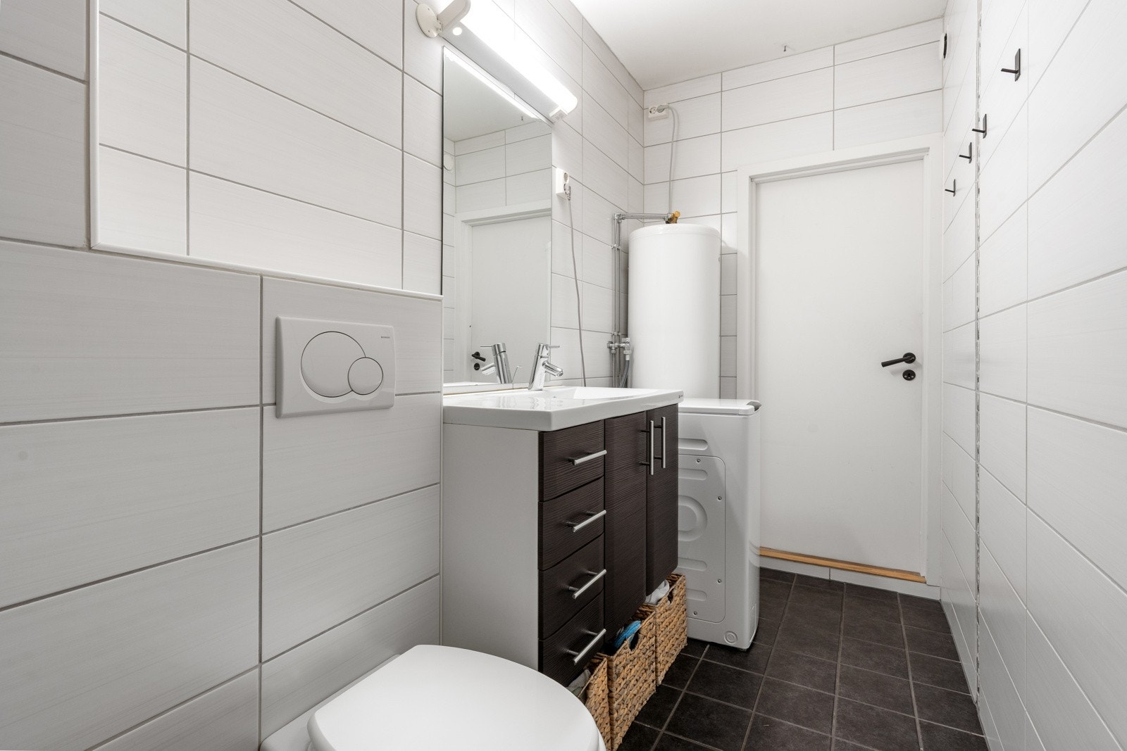 Ellers er badet innredet med baderomsinnredning med oppbevaringsplass og dusjkabinett.