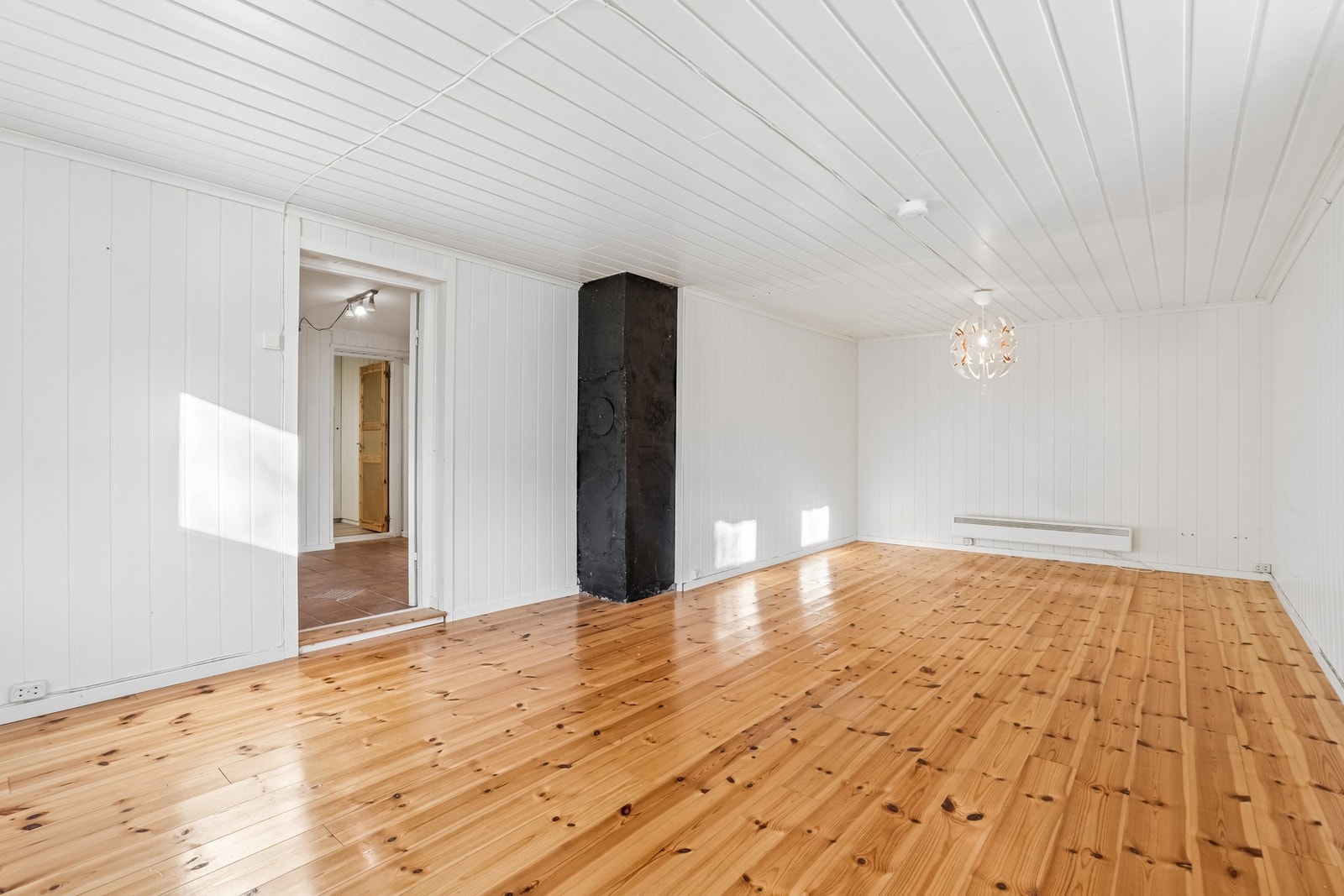 Kjellerstue med originalt tregulv og panel på veggene. Et fleksibelt rom med mange bruksmuligheter. Galleribilde