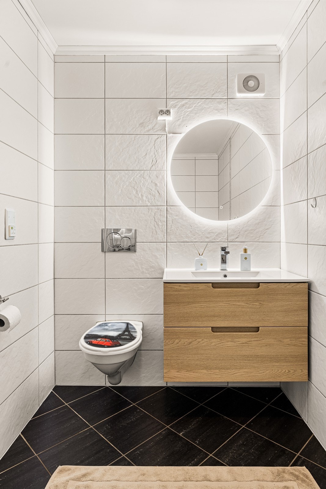 Badet har veggmontert toalett og en moderne innredning med nedfelt servant. Galleribilde