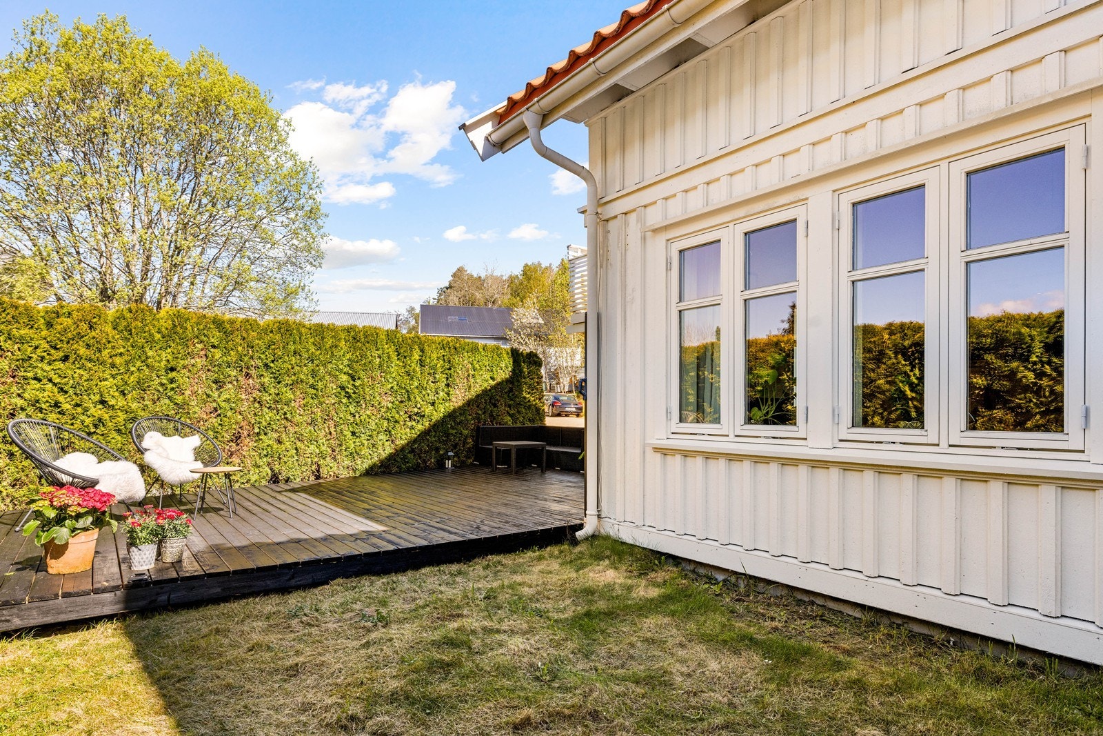 Terrassen i første etasje er omkranset av hekk, som gir en privat og usjenert uteplass. Galleribilde