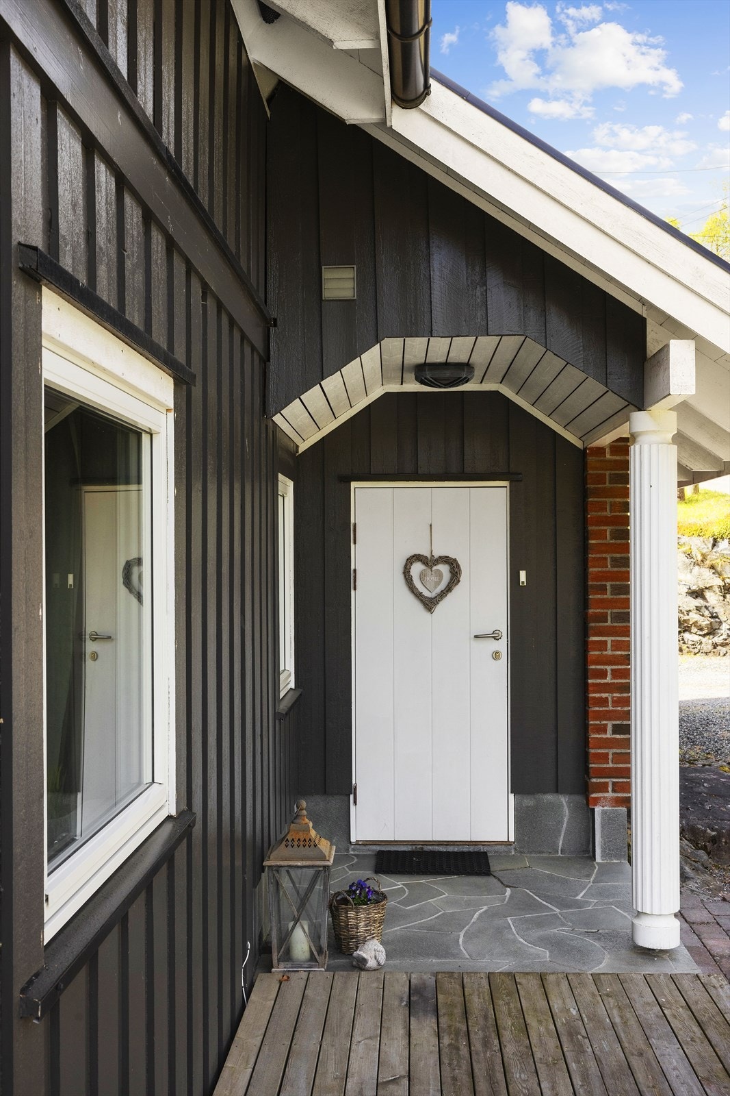 Inngangspartiet er overbygd og delvis forblendet med teglstein, som gir en solid og innbydende velkomst. Galleribilde