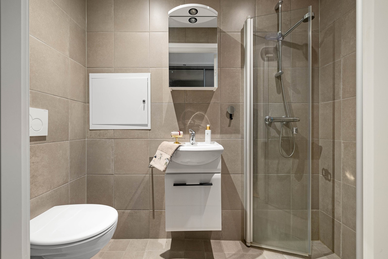 Badet ved entreen er et naturlig gjestebad og av et mer kompakt format, men fullt utstyrt. Galleribilde