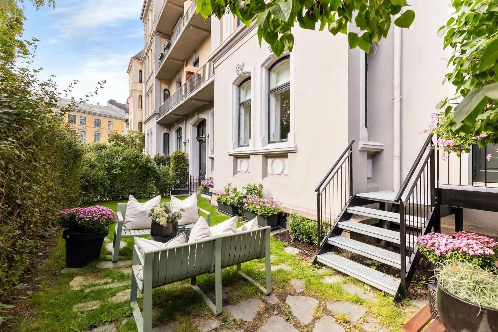 Frodig og pent opparbeidet forhage med trapp fra balkongen. Galleribilde