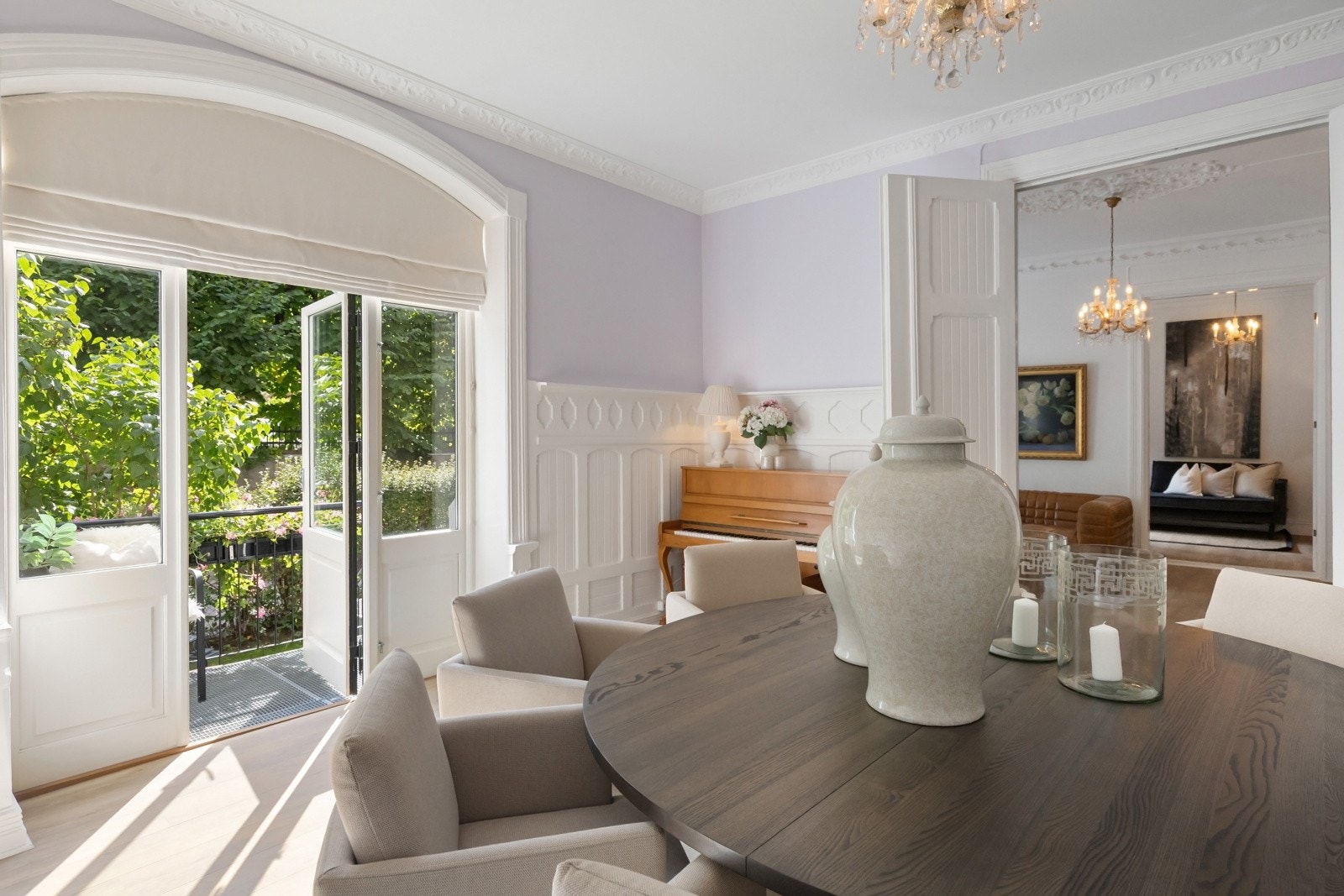 Stor spisestue med klassiske detaljer som stukkatur, rosett, brystpanel og vedovn. Galleribilde