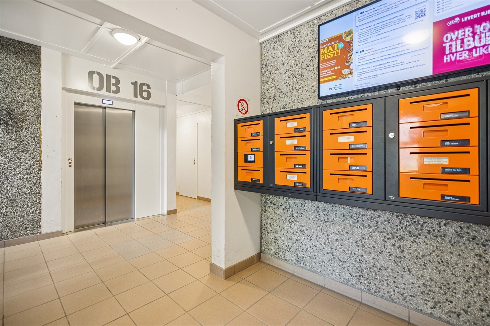 Felles inngangsparti med personheis, postkasser og digital informasjonstavle. Galleribilde