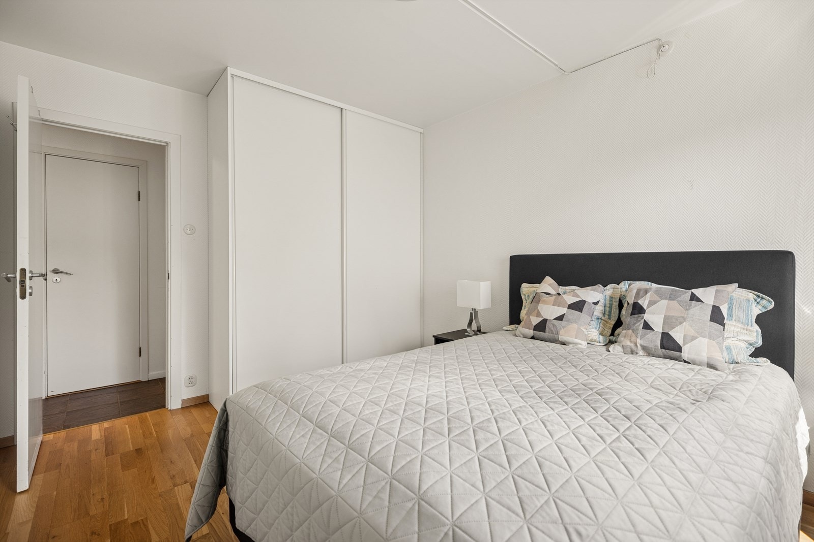 Romslig soverom med god plass til dobbeltseng og praktisk skyvedørsgarderobe. Galleribilde