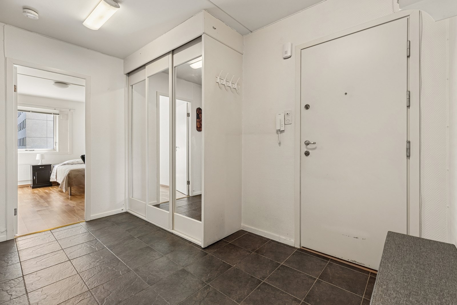 Entréen har flislagt gulv og praktisk skyvedørsgarderobe, med enkel adkomst videre til leilighetens rom. Galleribilde