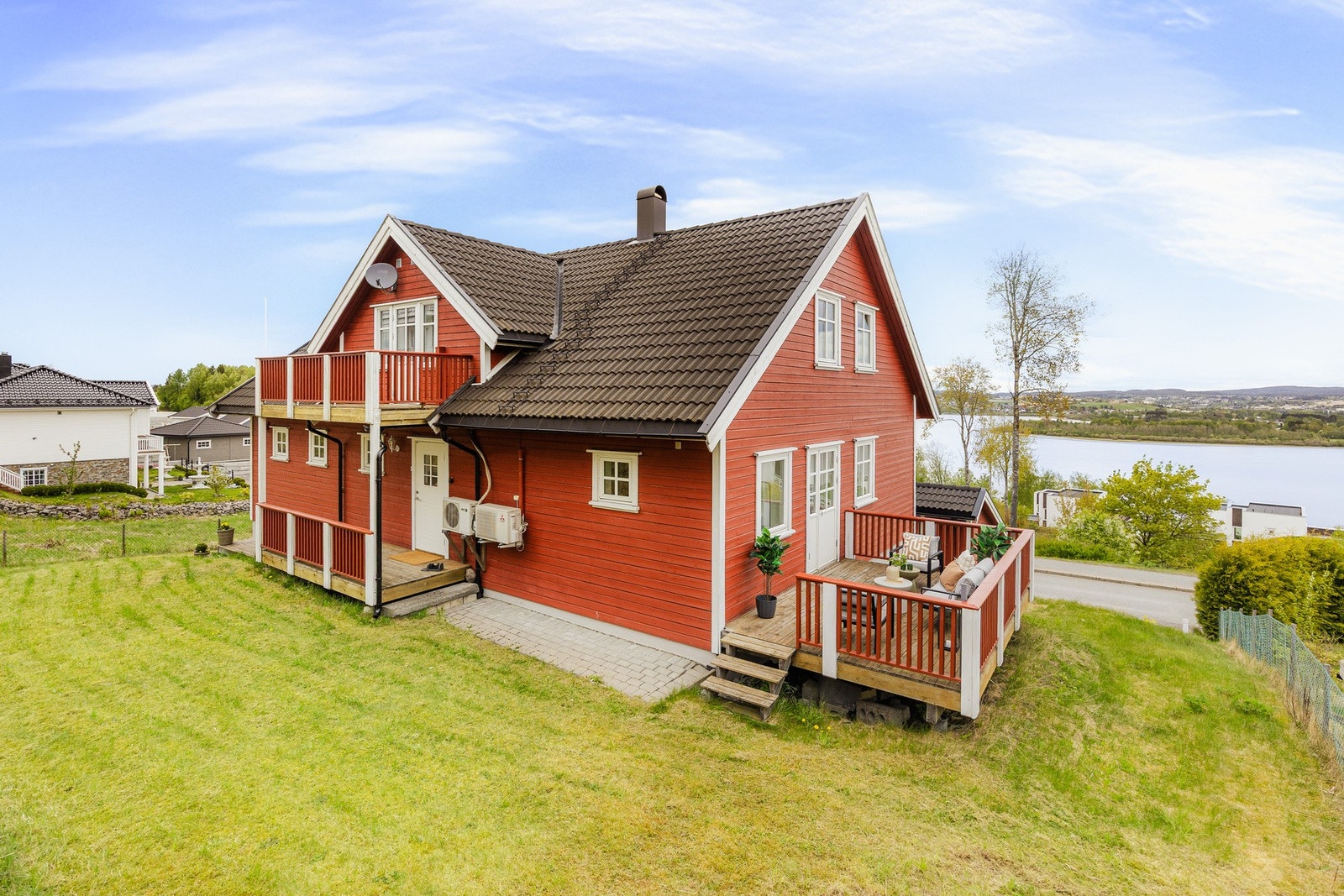 De grønne omgivelsene bidrar til en lun og privat atmosfære rundt boligen, samtidig som uteområdet fremstår lettstelt og familievennlig. Galleribilde