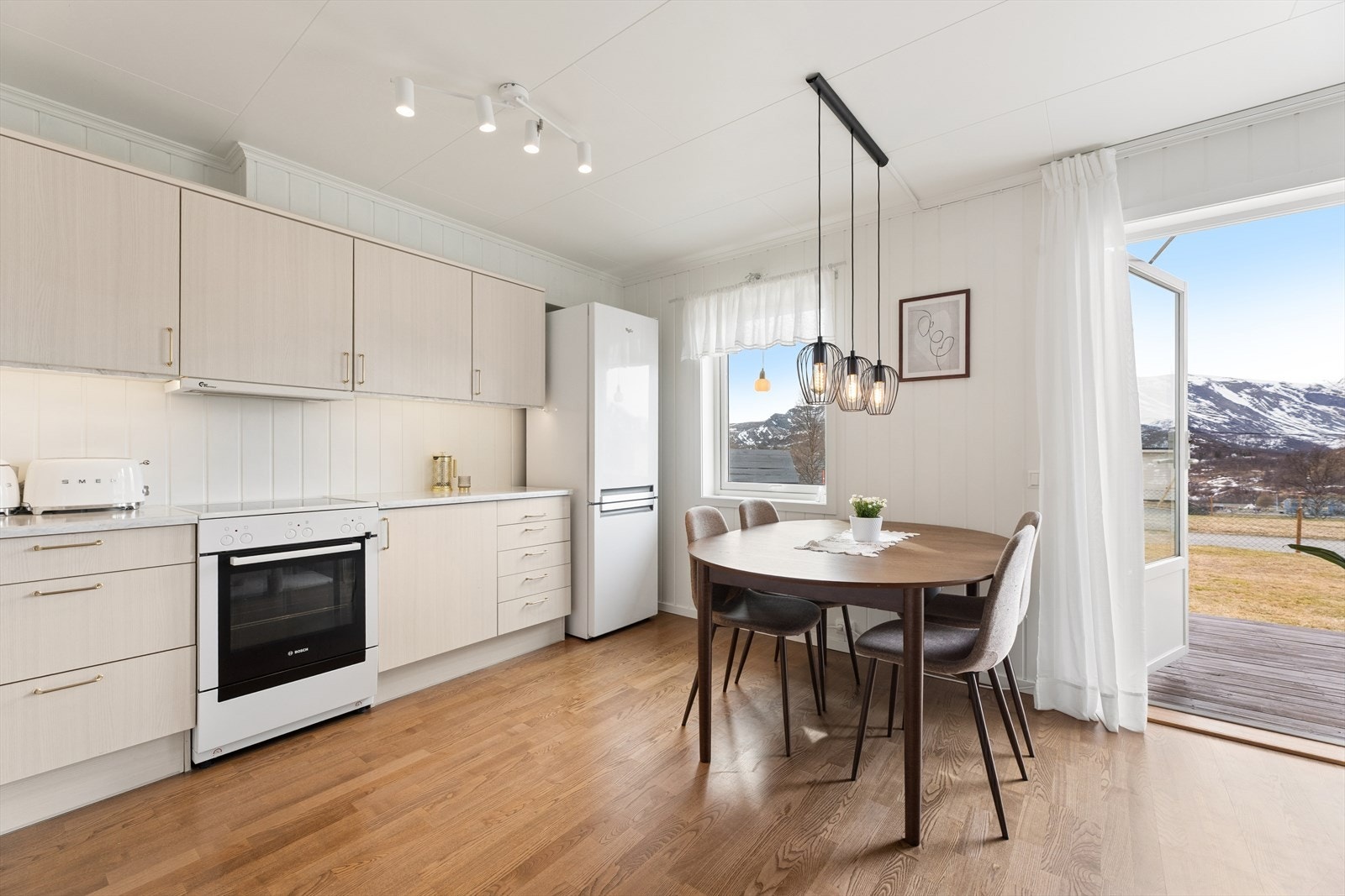 Kjøkkenet er praktisk innredet med frittstående hvitevarer og kjøkkenventilator med avtrekk ut. Galleribilde