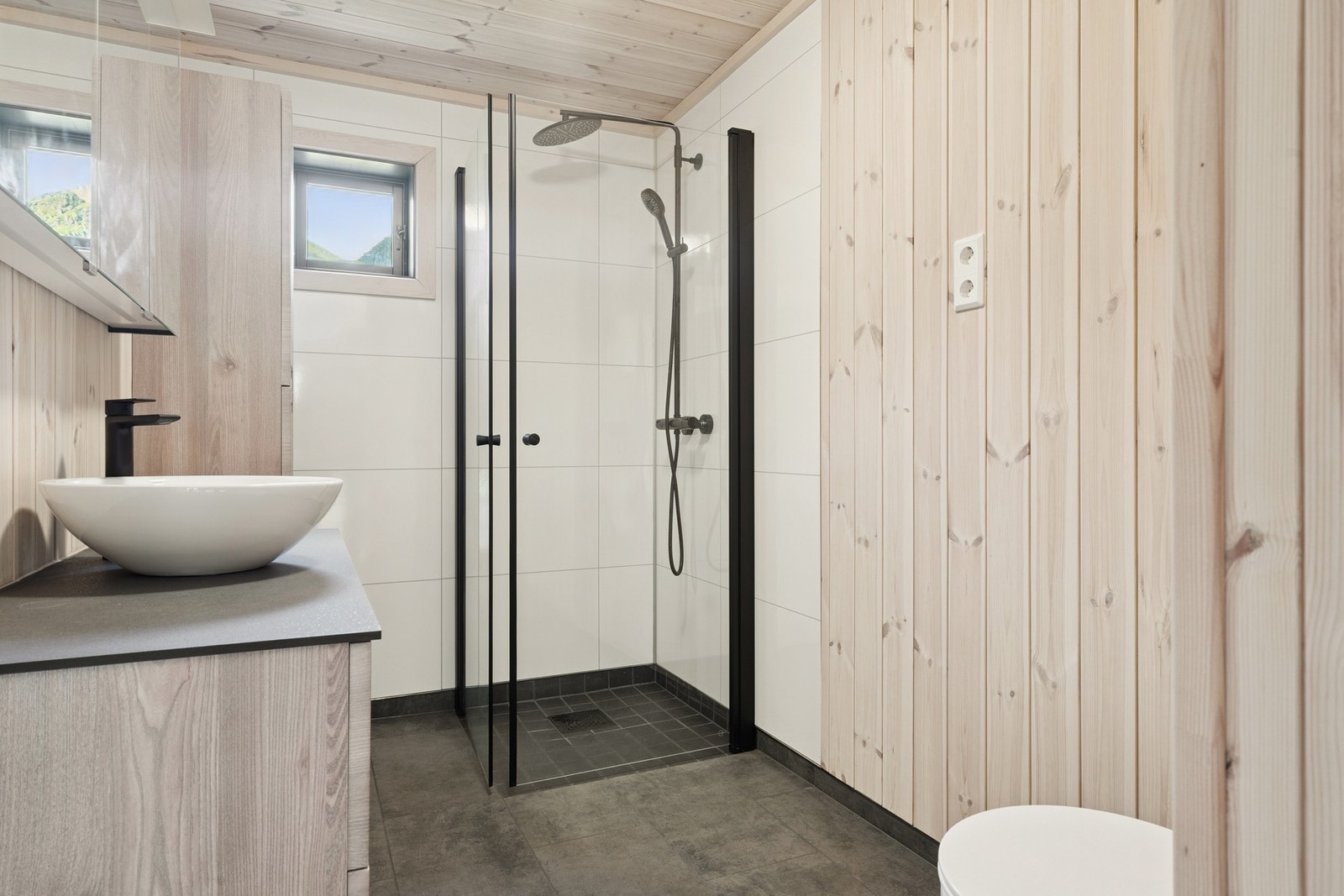 Badet i første etasje har flislagt gulv med elektriske varmekabler, dusjhjørne og baderomsplater på veggene i dusjsonen. Galleribilde
