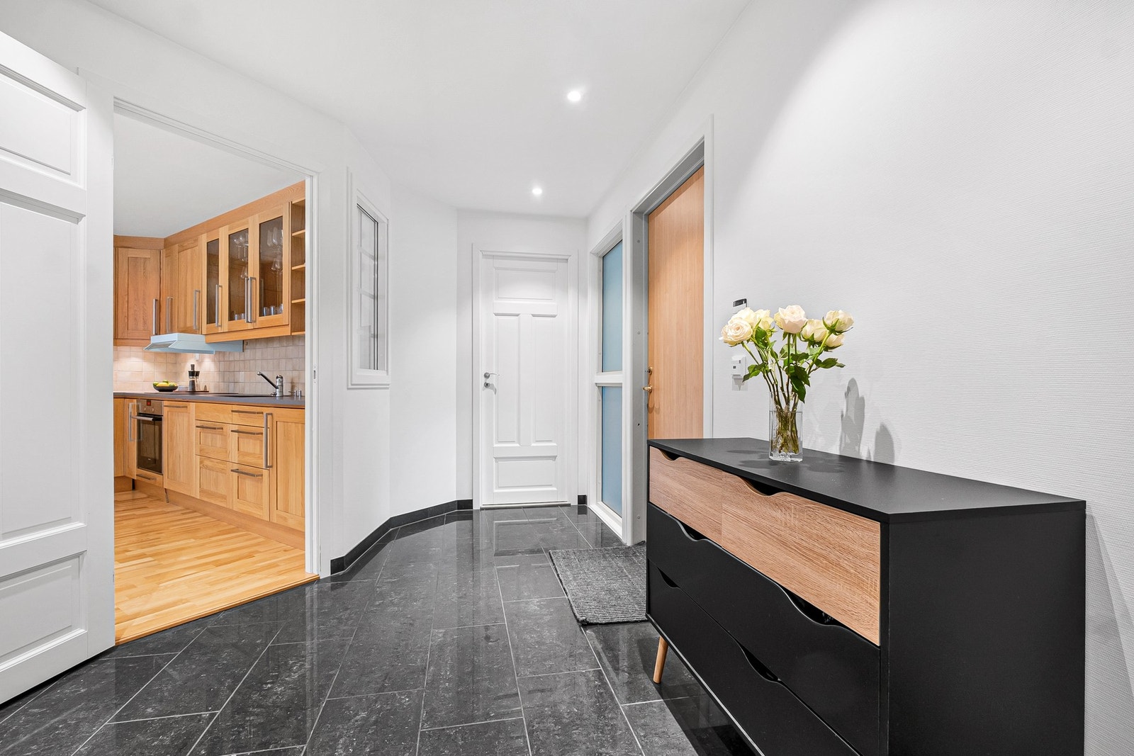 Romslig og innbydende entré med fliser på gulv. Innredning med skyvedørsgarderobe og god plass til diverse oppbevaring Galleribilde