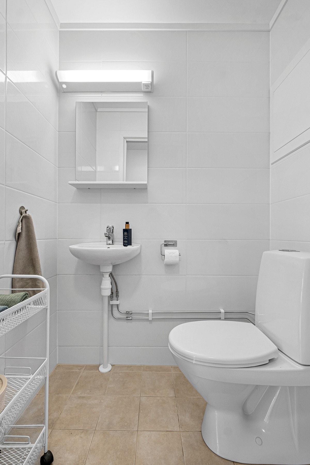 Praktisk, flislagt toalettrom vegg-i-vegg med badet Galleribilde