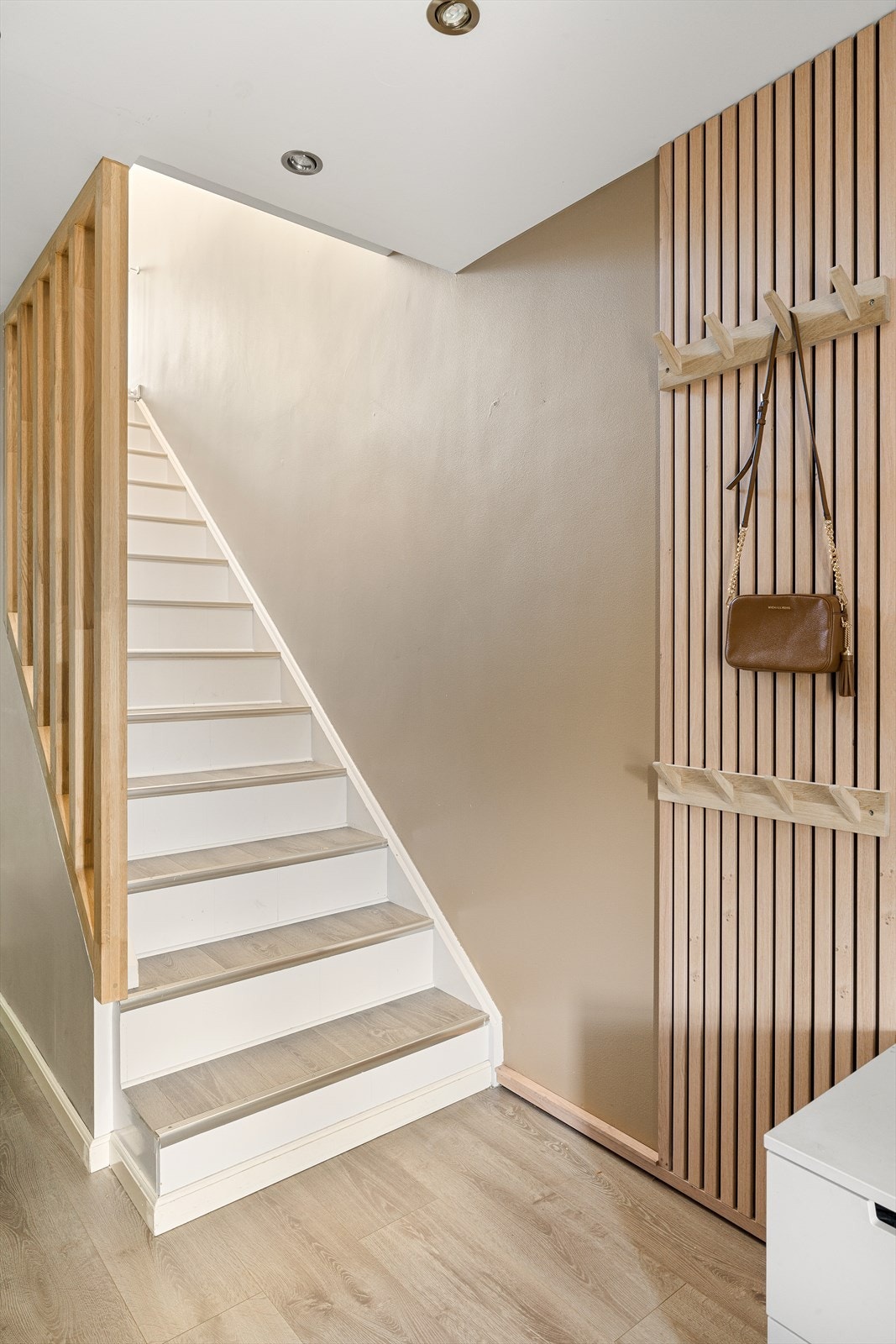Fra gangen leder en malt tretrapp med laminat i trinnene opp til andre etasje. Galleribilde