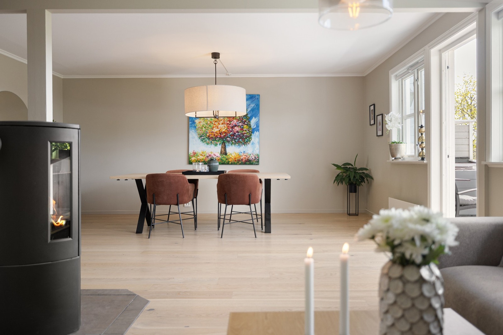 Mellom sonene står en stilfull peisovn med glass på tre sider - et naturlig samlingspunkt som tilfører både varme og atmosfære i vinterhalvåret. Galleribilde