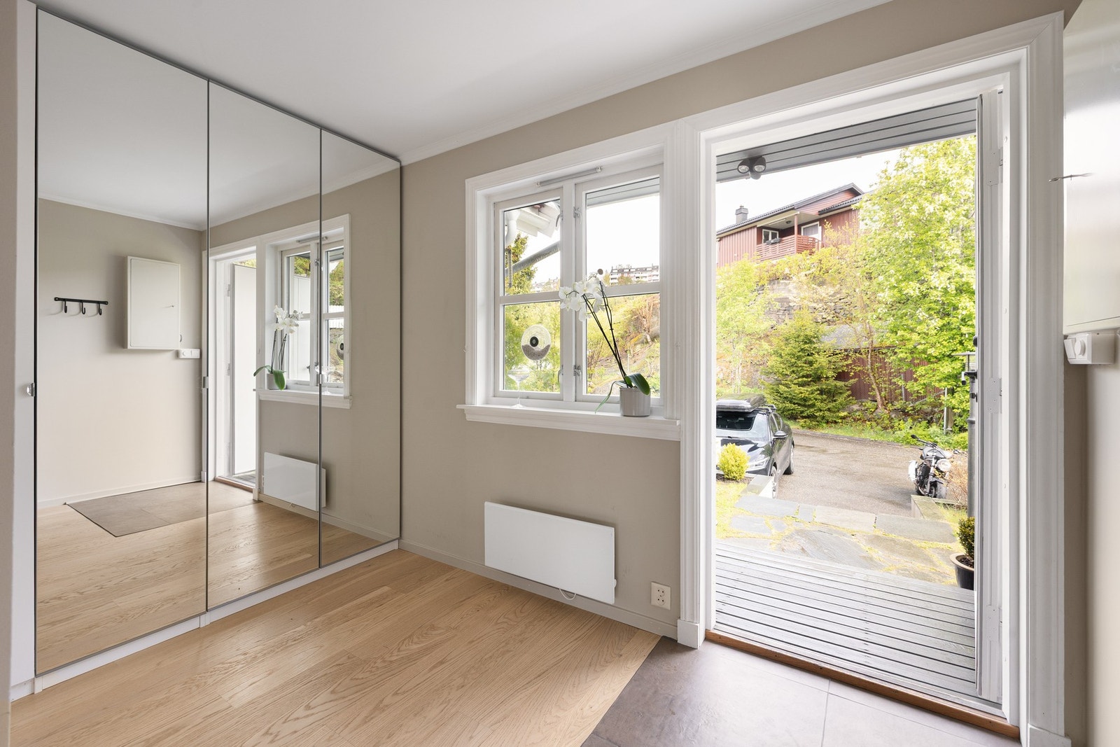 Lys og innbydende entré med en praktisk planløsning og god oppbevaringsplass i speilgarderobe langs veggen. Galleribilde