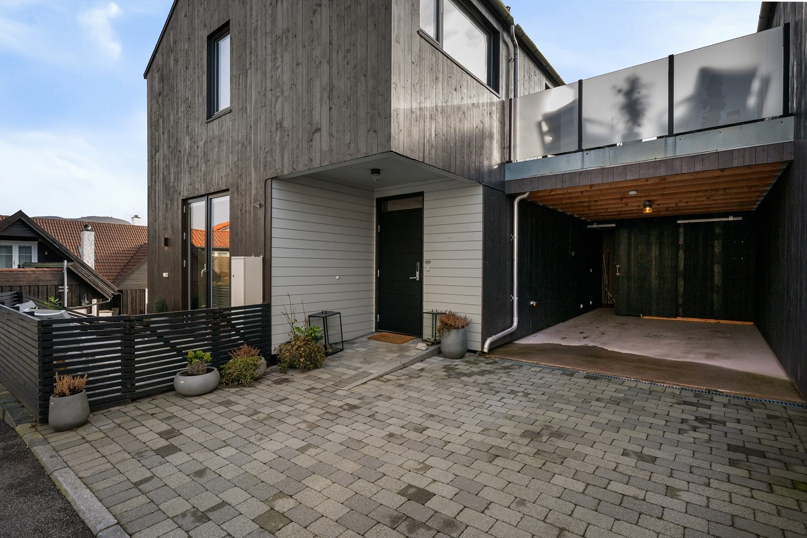 Gårdsrom med plass til bil, samt biloppstilling på siden av huset og i front i tillegg til carport med bod og elbil-lader. Galleribilde