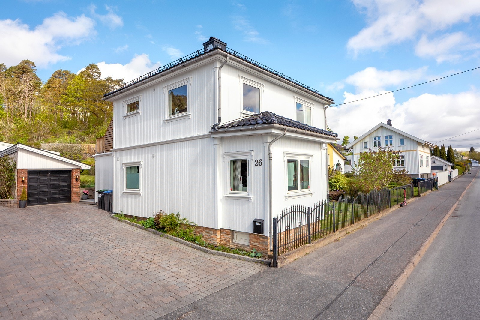 Eiendommen har en steinbelagt gårdsplass, samt smijernsgjerde mot veien som gir et klassisk uttrykk. Galleribilde