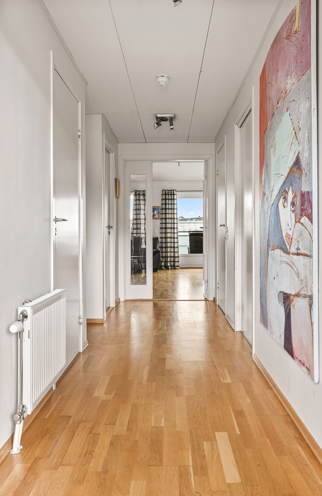 Innbydende entré med spotter i himlingen som gir et moderne uttrykk. Glassdør mot stuen bidrar til ekstra lysinnslipp og en luftig romfølelse allerede fra inngangspartiet. Galleribilde
