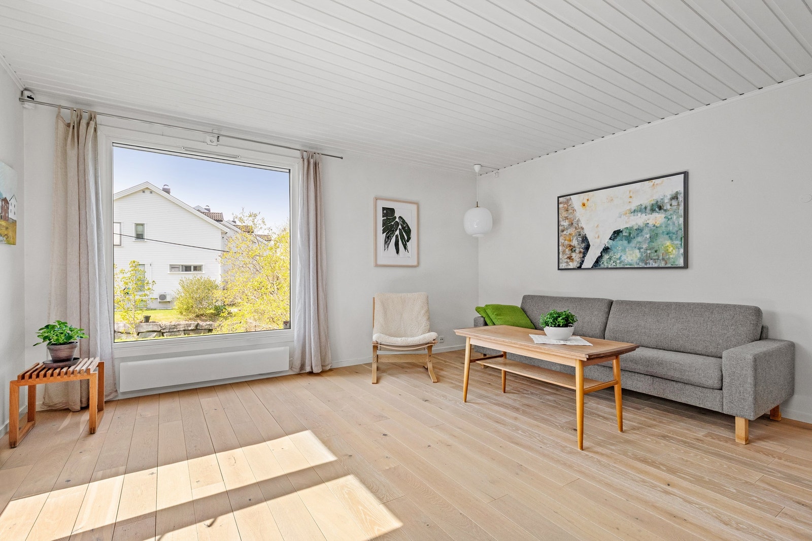 De store vindusflatene gir mye naturlig lys inn til rommet og et fint utsyn mot hagen Galleribilde