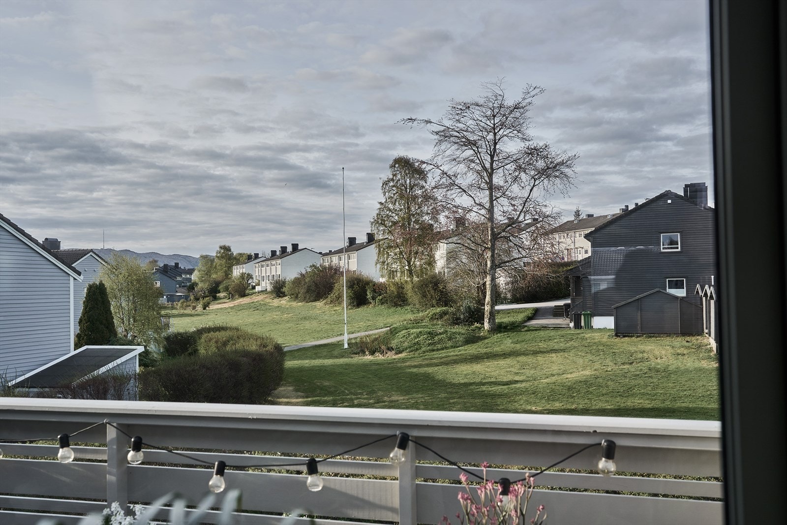 Fra balkongen ser man ut over grønne fellesarealer. Galleribilde