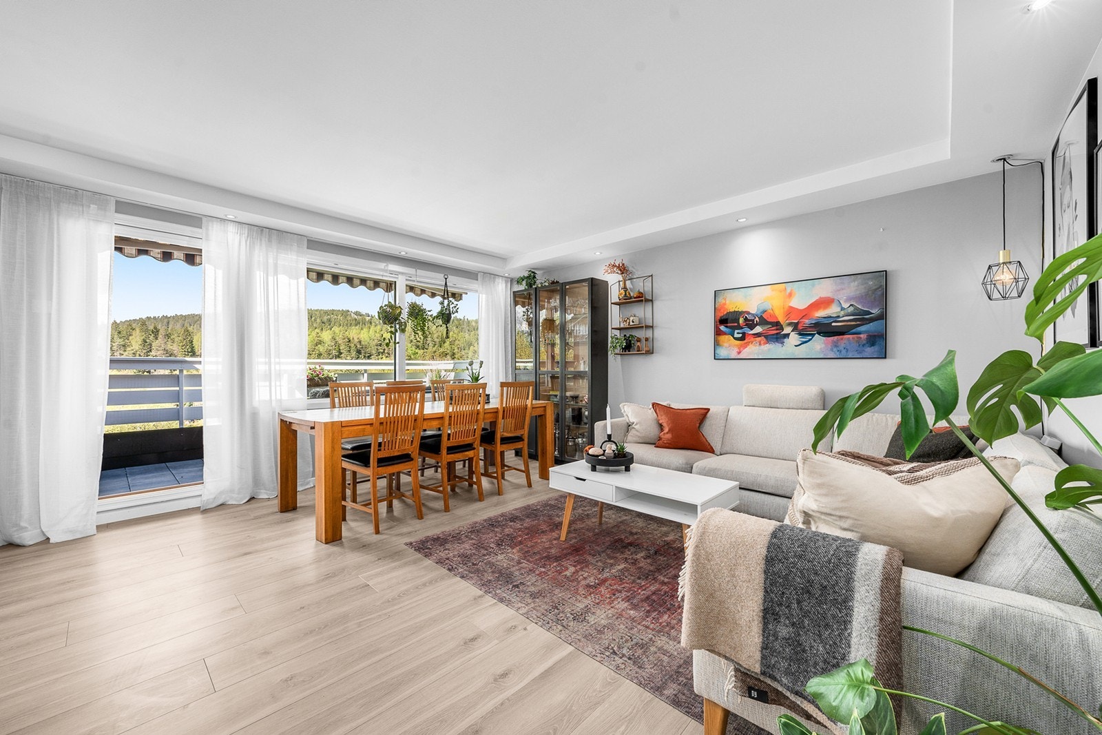 Lys og romslig stue med god plass til både sofagruppe og spisebord. De store vindusflatene slipper inn rikelig med naturlig lys og gir rommet en luftig og innbydende atmosfære. Galleribilde