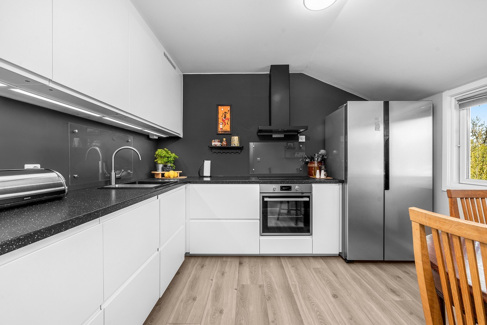 Delikat kjøkkeninnredning fra 2020 med hvite, slette fronter og laminat benkeplate. Galleribilde
