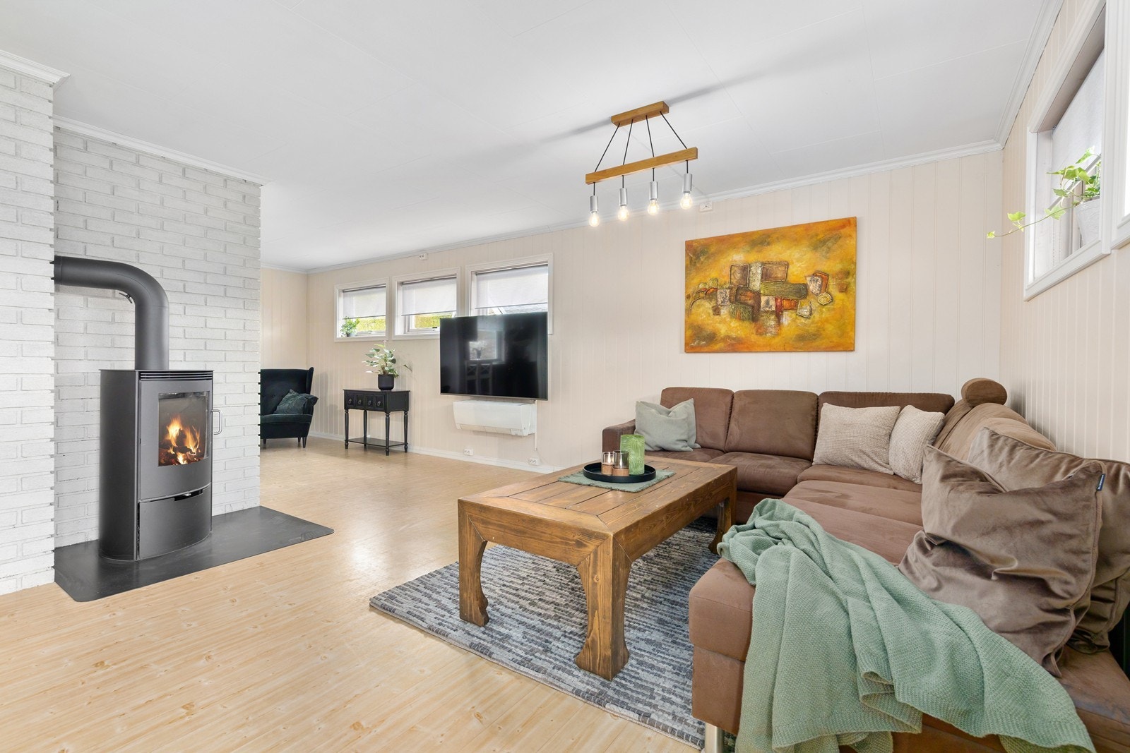 En frittstående vedovn sentralt plassert i stuen, gir både varme og hygge. Galleribilde