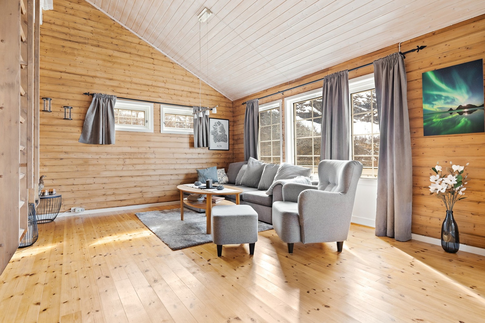 Lys og luftig stue med god takhøyde og panel på vegger. Galleribilde