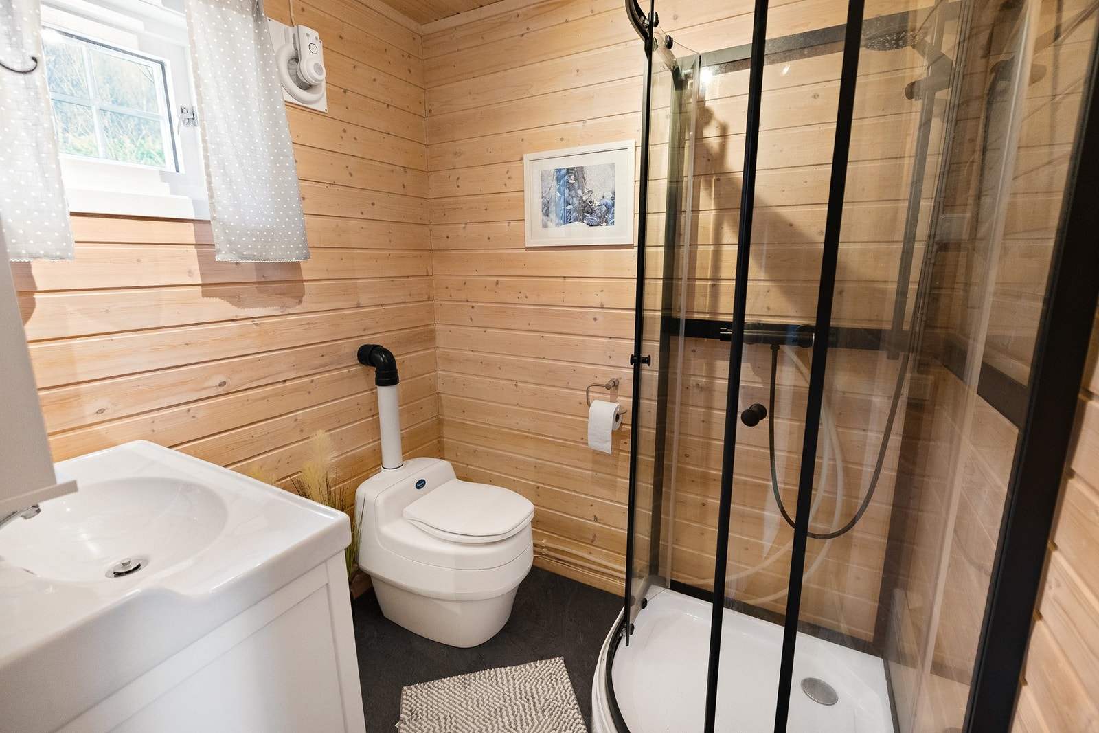 Badet er utstyrt med et praktisk dusjkabinett. Galleribilde
